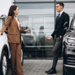 young couple choosing car car showroom